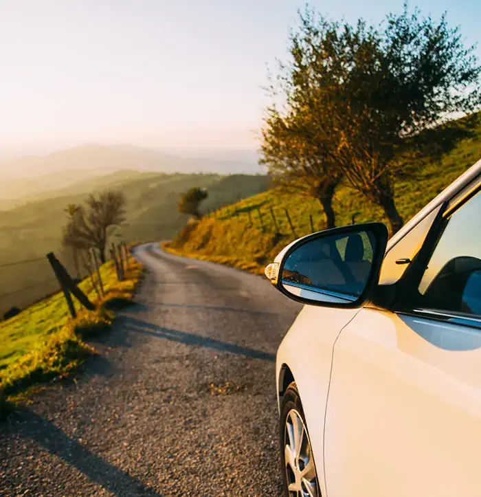 丘に佇む車から見る夕焼けの空